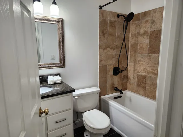 a white toilet sitting next to a bath tub