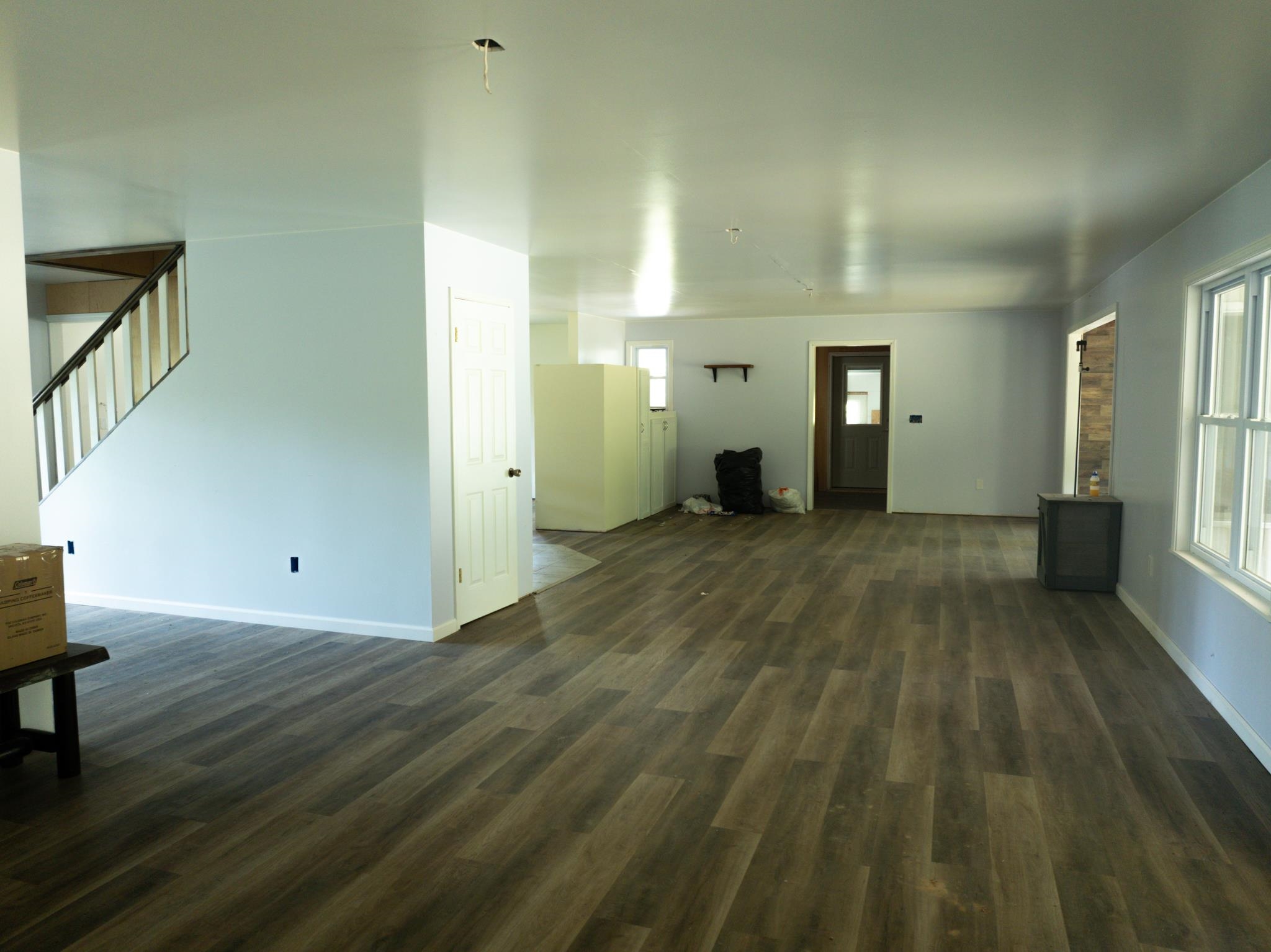 1421 Copper Spring Road Springville, TN 38256 - Photo 13 of 40 Expansive interior featuring wood-finish flooring, light-toned walls, and a staircase with dark handrails