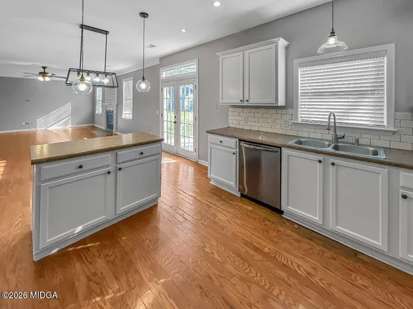 a kitchen with a sink a stove a refrigerator and white cabinets