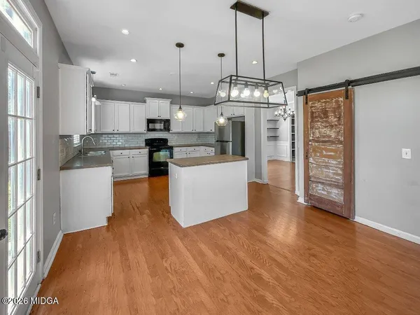 a kitchen with granite countertop white cabinets and refrigerator