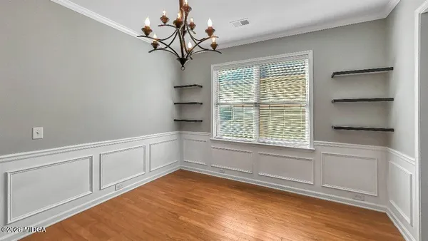 an empty room with windows and ceiling fan