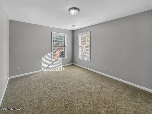 an empty room with a window and a fan