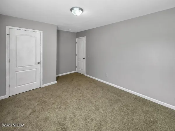 an empty room with windows and closet