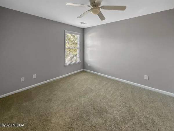 an empty room with a window and a fan