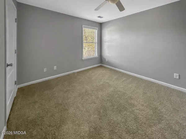 an empty room with a window and a fan
