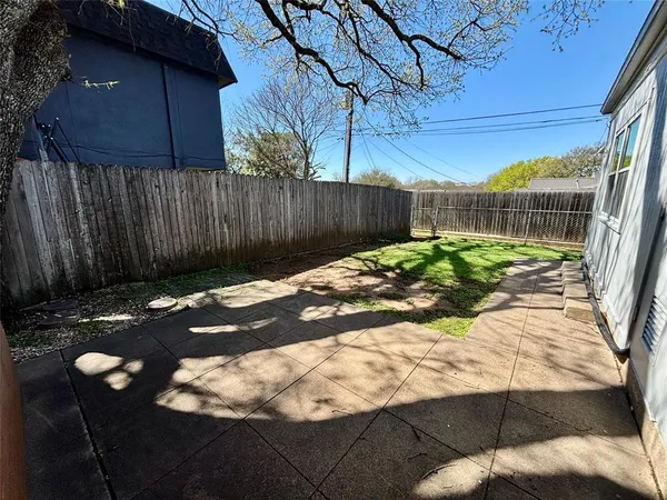 a view of backyard with wooden fence
