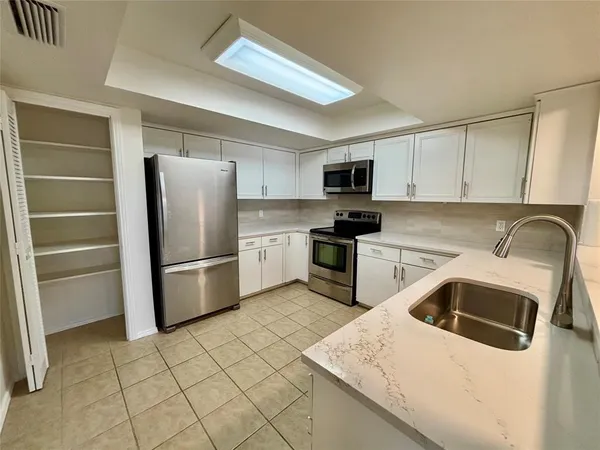 a kitchen with a refrigerator sink and microwave