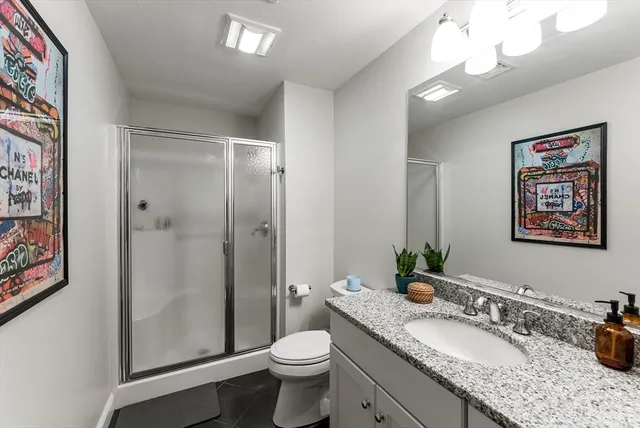 a bathroom with a granite countertop sink toilet and shower