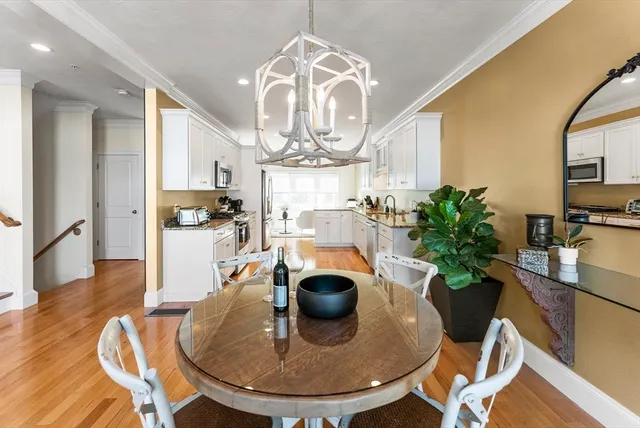a view of a dining room with furniture a chandelier and wooden floor