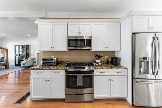 a kitchen with white cabinets and stainless steel appliances