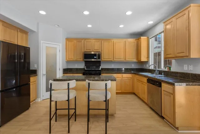 a kitchen with stainless steel appliances kitchen island granite countertop a refrigerator and microwave
