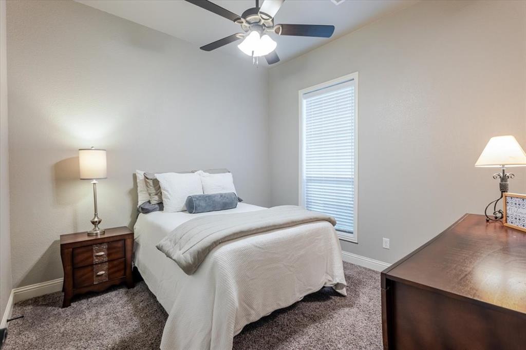 104 Lagrange Court Weatherford, TX 76088 - Photo 16 of 25 a bedroom with a bed and a lamp on table