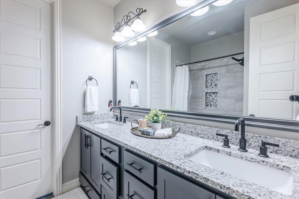 104 Lagrange Court Weatherford, TX 76088 - Photo 19 of 25 a bathroom with double vanity sinks a vanity and a large mirror
