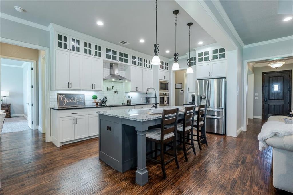 104 Lagrange Court Weatherford, TX 76088 - Photo 7 of 25 a kitchen with granite countertop a counter space dining table and stainless steel appliances