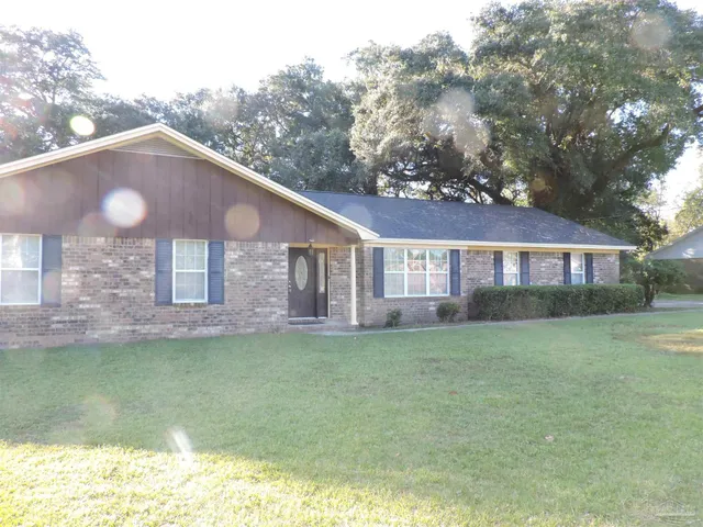 a front view of a house with a garden and lake view