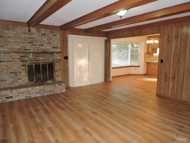 a view of empty room with wooden floor and fireplace