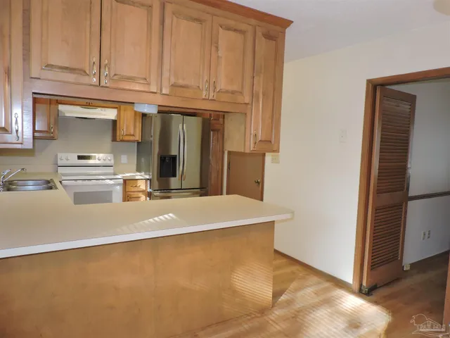 a kitchen with stainless steel appliances granite countertop a refrigerator a stove a sink and dishwasher