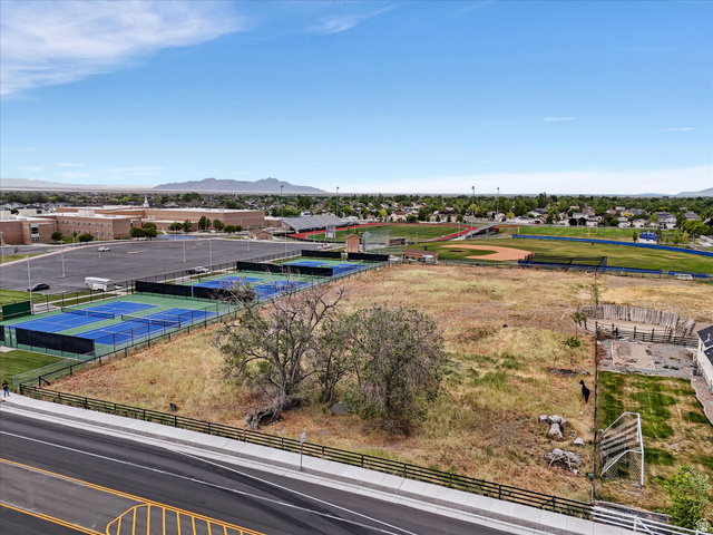 149 Bates Canyon Road Stansbury Park, UT 84074 - Photo 8 of 9 Expansive undeveloped lot featuring a natural landscape and surrounding amenities including paved tennis courts, a baseball field, and academic buildings