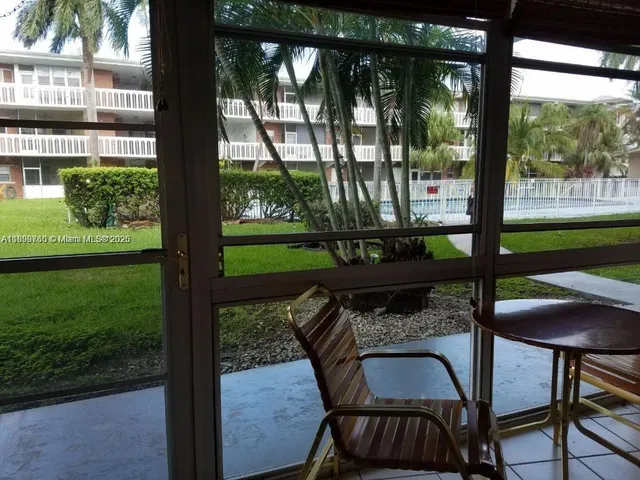 a view of a porch with a table chairs and a yard