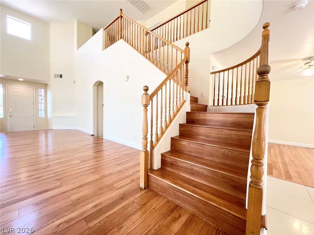 9891 Ridge Hill Avenue Las Vegas, NV 89147 - Photo 12 of 29 Hardwood flooring flows throughout this entryway with a grand wooden staircase.
