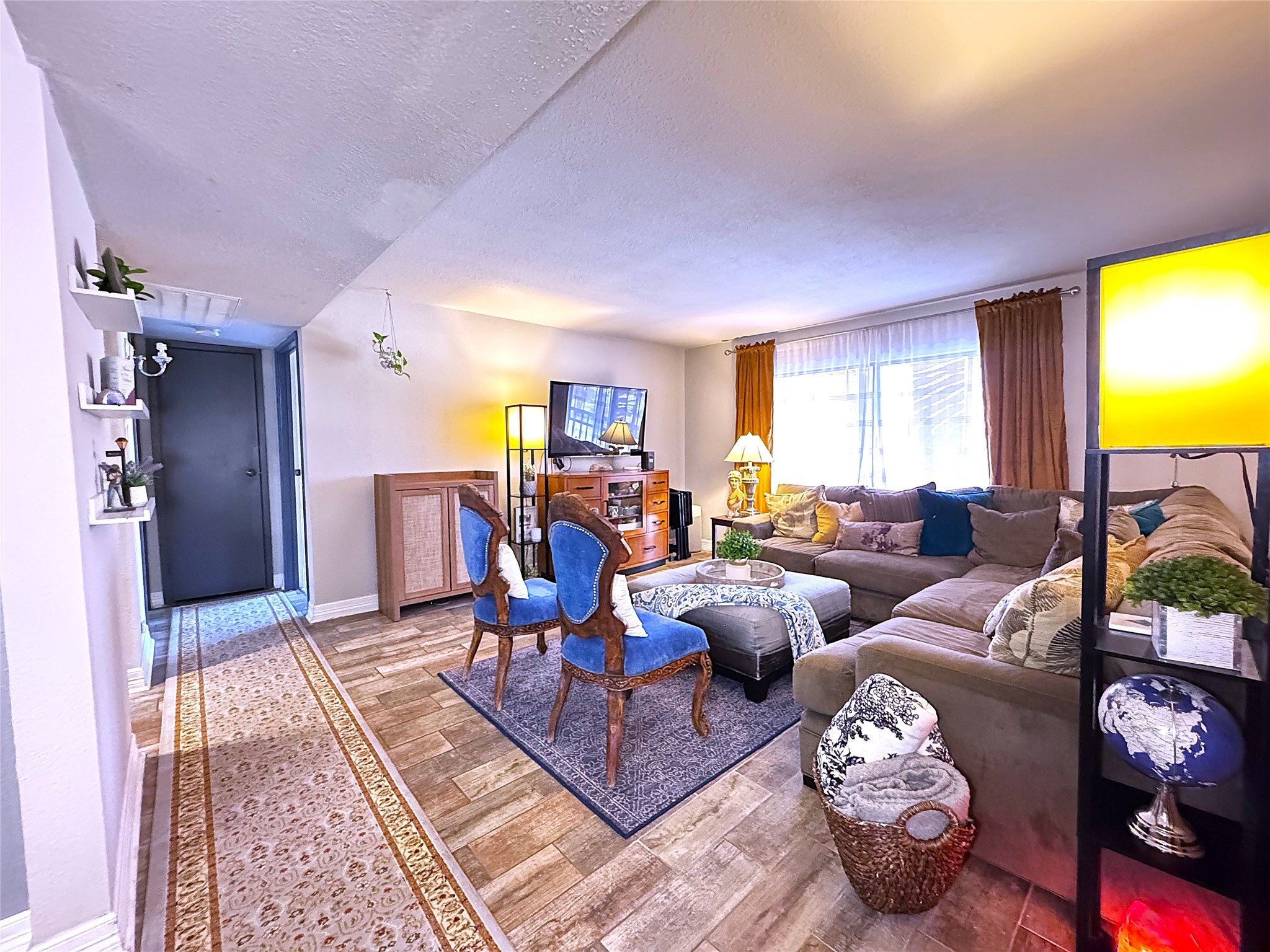 a living room with furniture a rug and a flat screen tv