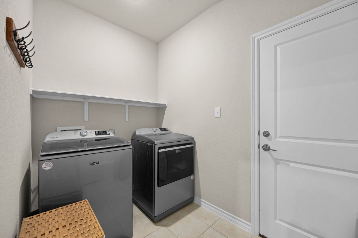 280 Pepperbark Loop Buda, TX 78610 - Photo 22 of 38 Laundry area featuring light tile patterned floors and washer and clothes dryer