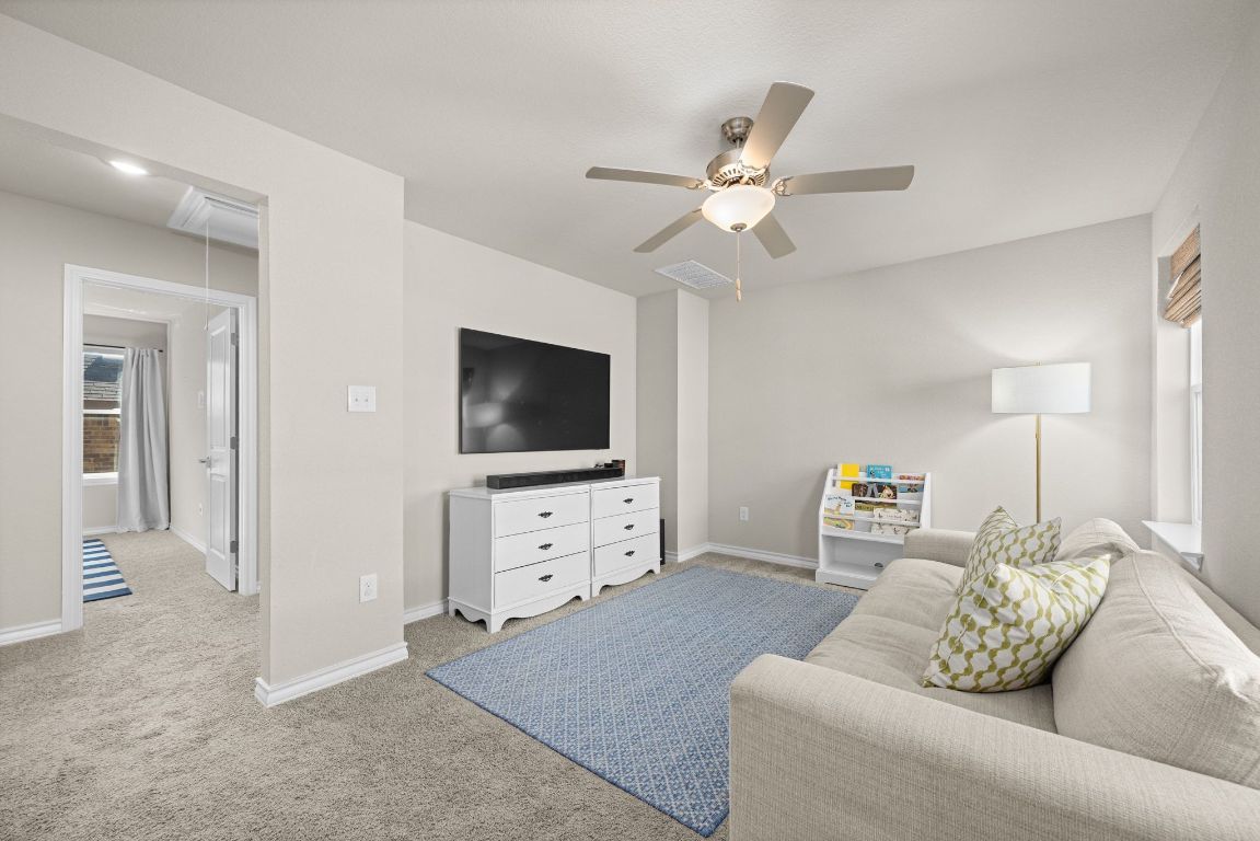 280 Pepperbark Loop Buda, TX 78610 - Photo 24 of 38 Living room with plenty of natural light, attic access, light colored carpet, and ceiling fan