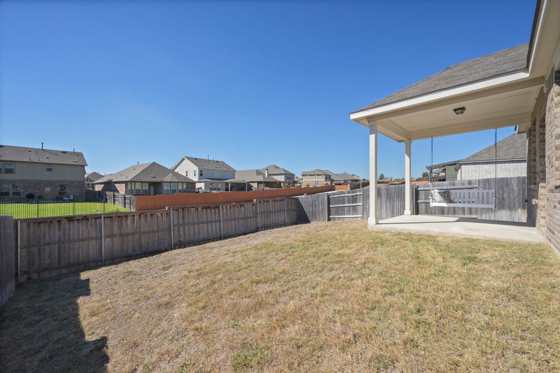 280 Pepperbark Loop Buda, TX 78610 - Photo 30 of 38 Fenced backyard with a residential view and a patio