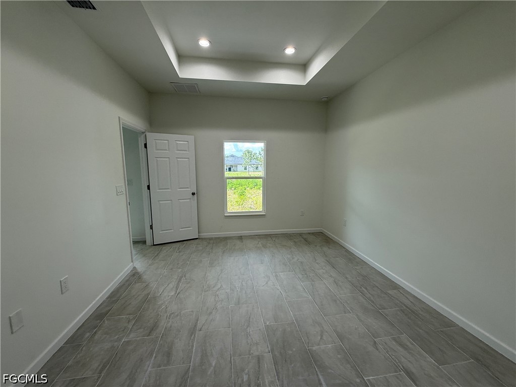 2809 Darlene Place Lehigh Acres, FL 33971 - Photo 11 of 26 an empty room with wooden floor and windows
