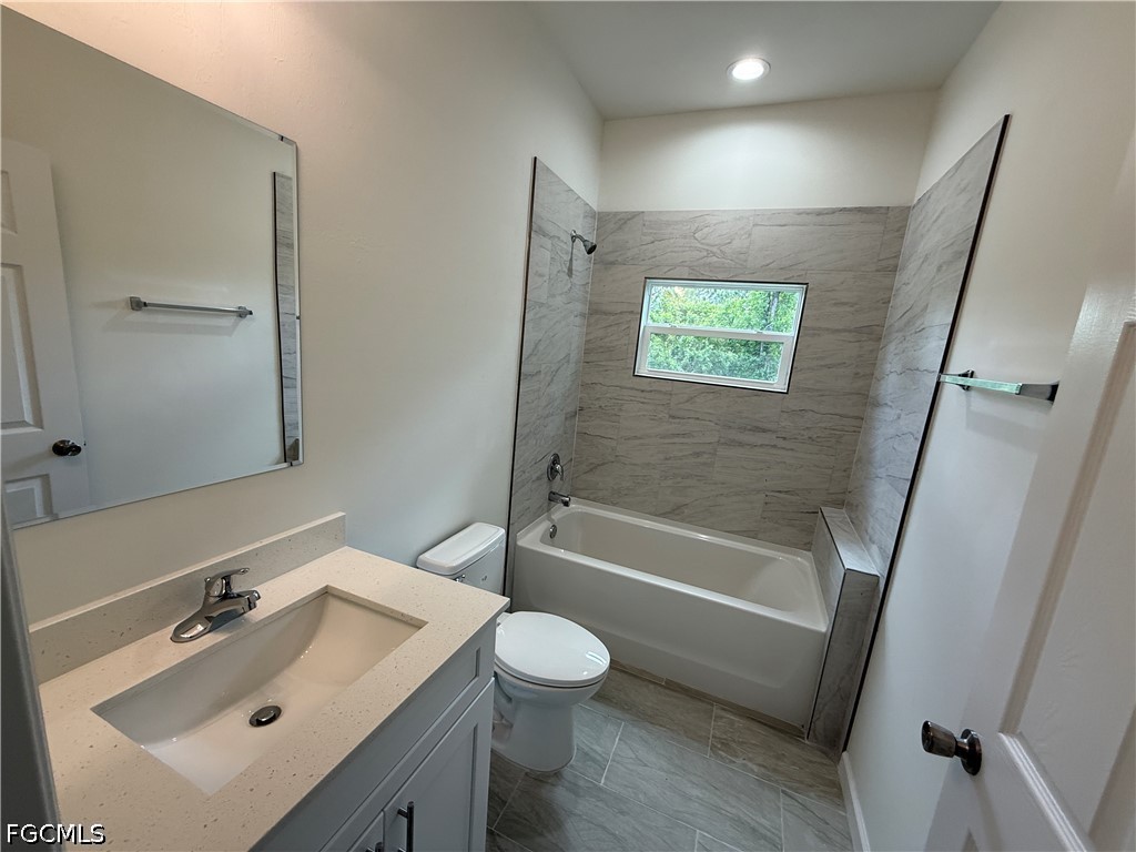 2809 Darlene Place Lehigh Acres, FL 33971 - Photo 17 of 26 a bathroom with a sink a toilet a tub and shower