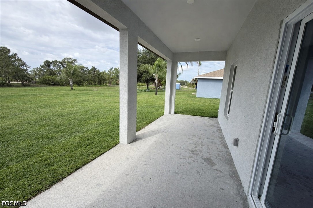 2809 Darlene Place Lehigh Acres, FL 33971 - Photo 22 of 26 a view of a porch with a big yard and potted plants