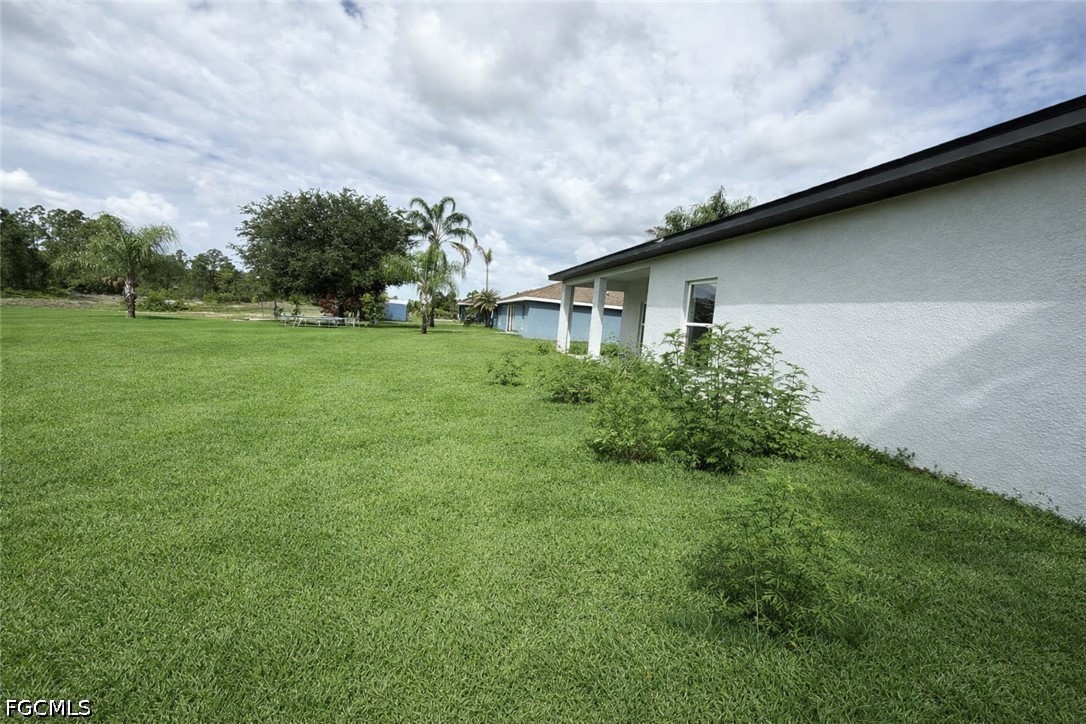 2809 Darlene Place Lehigh Acres, FL 33971 - Photo 24 of 26 a view of a backyard with large trees