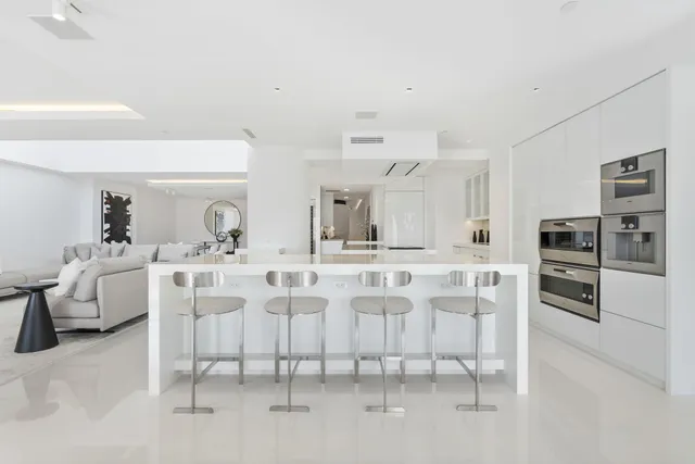 a kitchen with stainless steel appliances kitchen island granite countertop a table and chairs in it