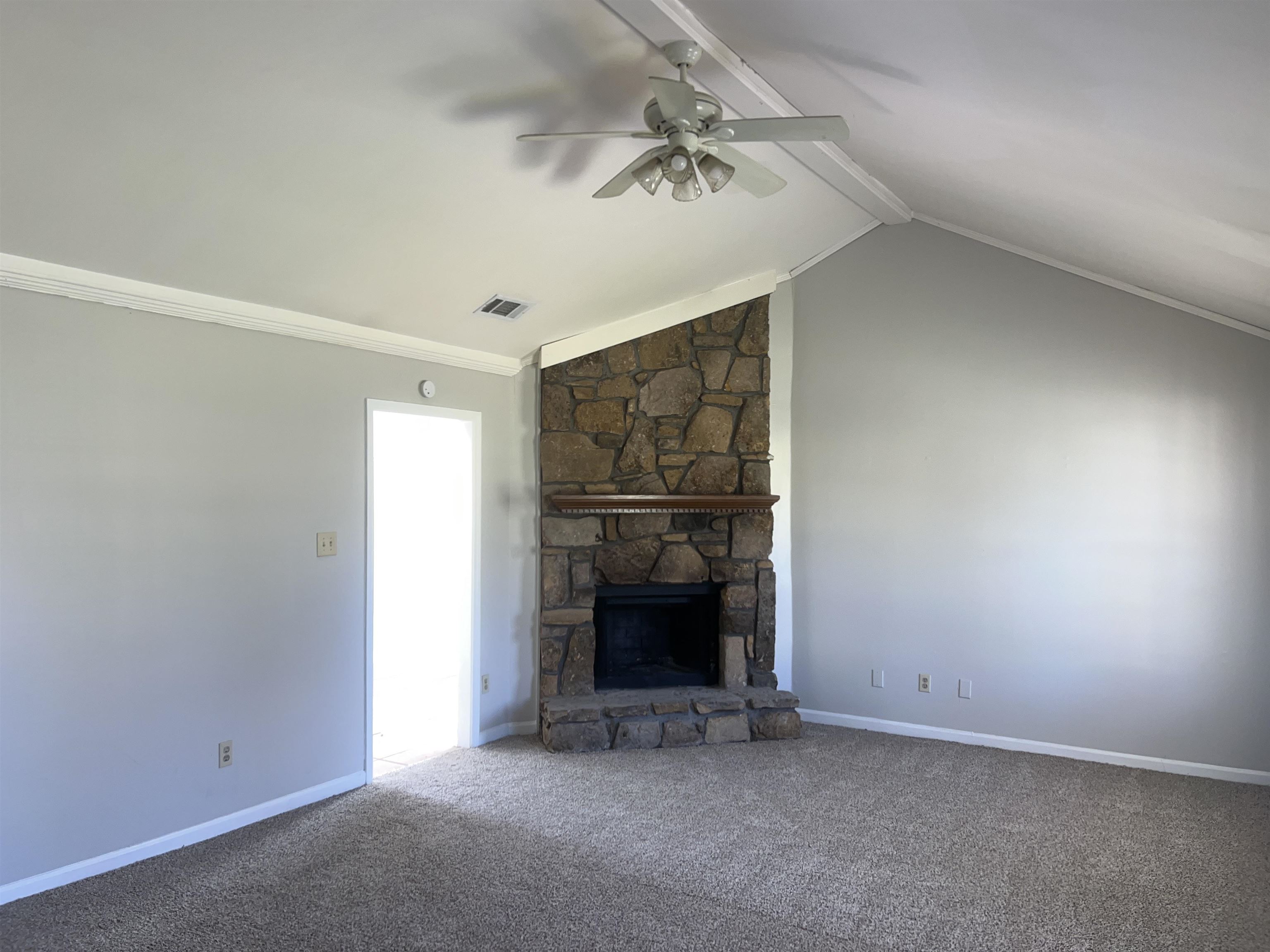 4609 Crestfield Road Millington, TN 38053 - Photo 3 of 8 Unfurnished living room with lofted ceiling with beams, a stone fireplace, crown molding, carpet flooring, and ceiling fan