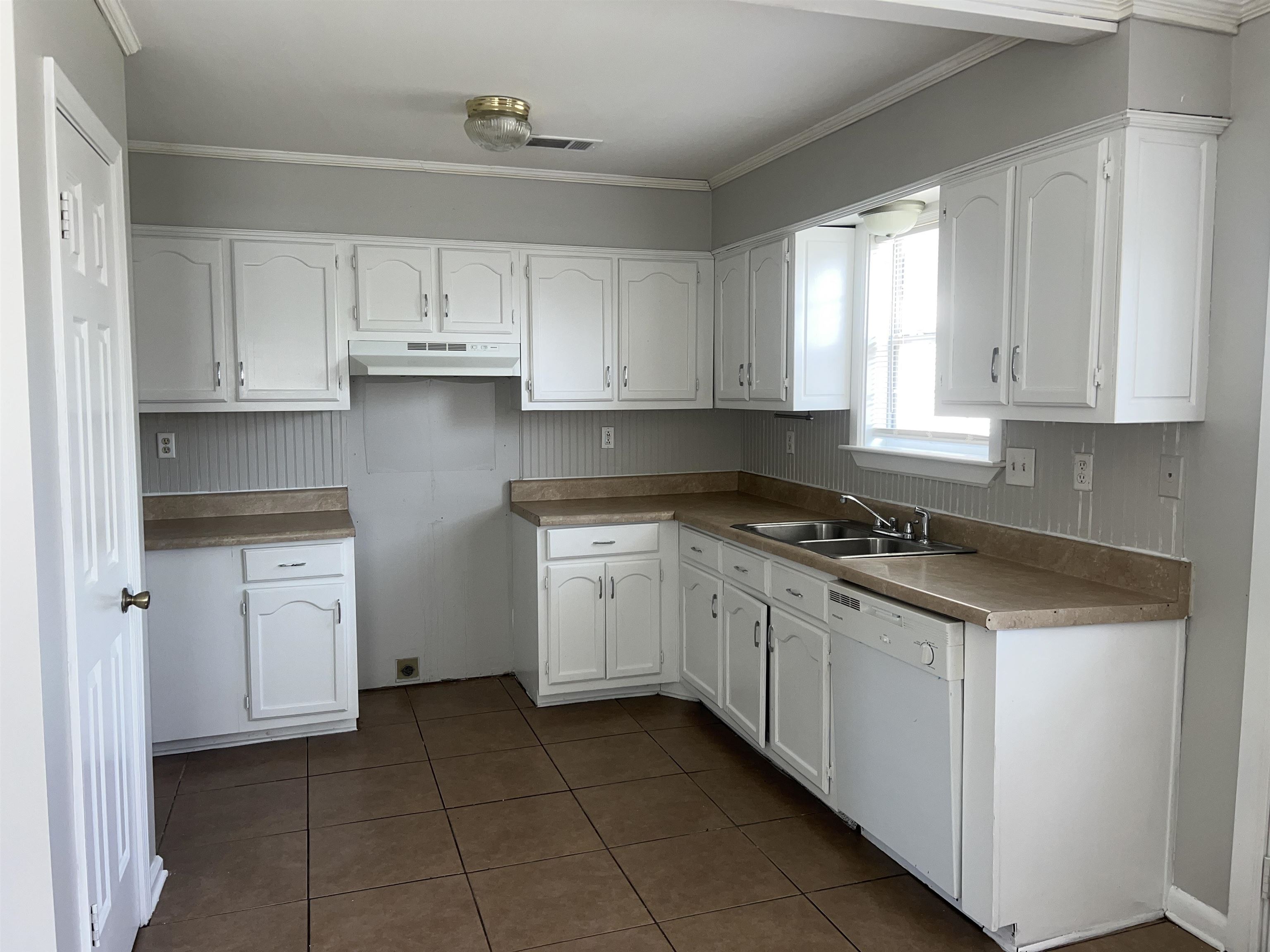 4609 Crestfield Road Millington, TN 38053 - Photo 5 of 8 Kitchen with sink, dark tile patterned floors, ventilation hood, white dishwasher, and white cabinets