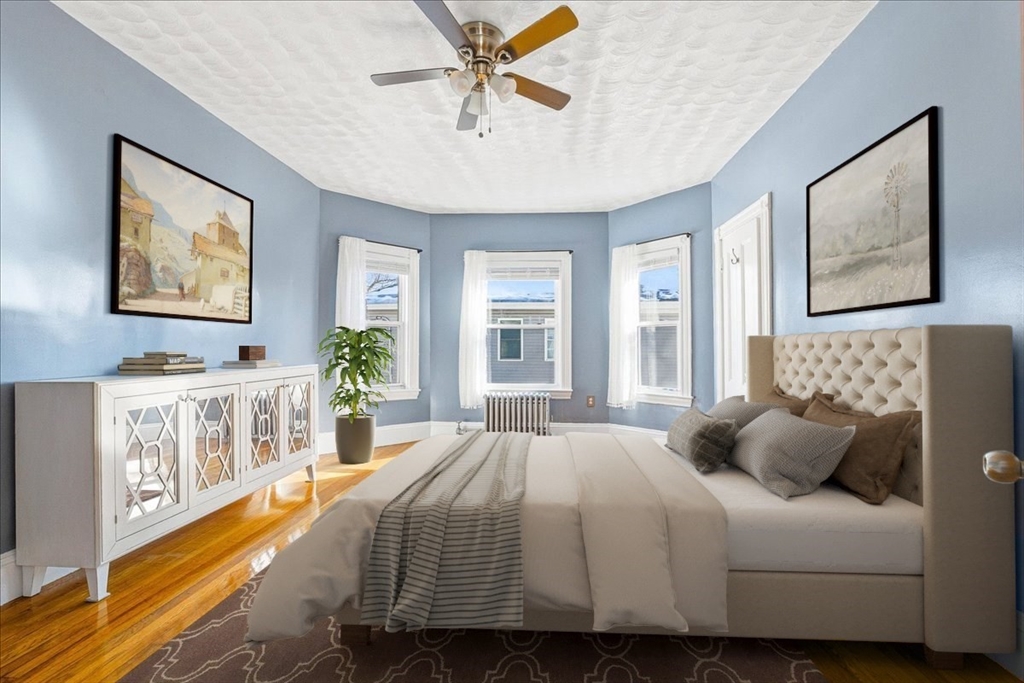 73 Hudson Street Milton, MA 02186 - Photo 17 of 42 a bedroom with a large bed a chandelier and windows