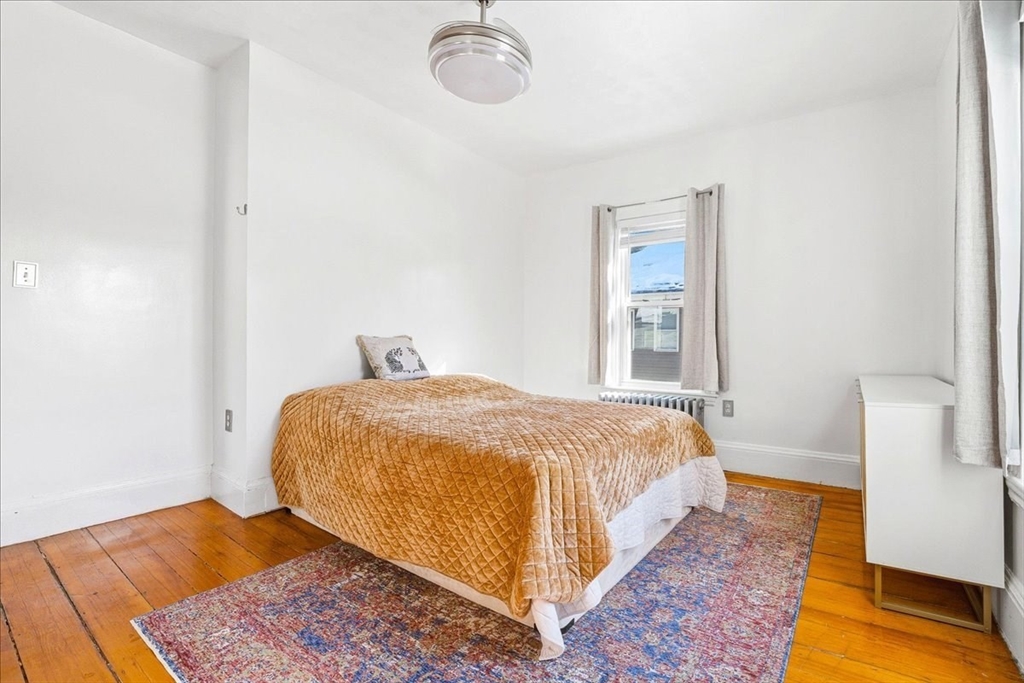 73 Hudson Street Milton, MA 02186 - Photo 21 of 42 a bedroom with a bed and wooden floor