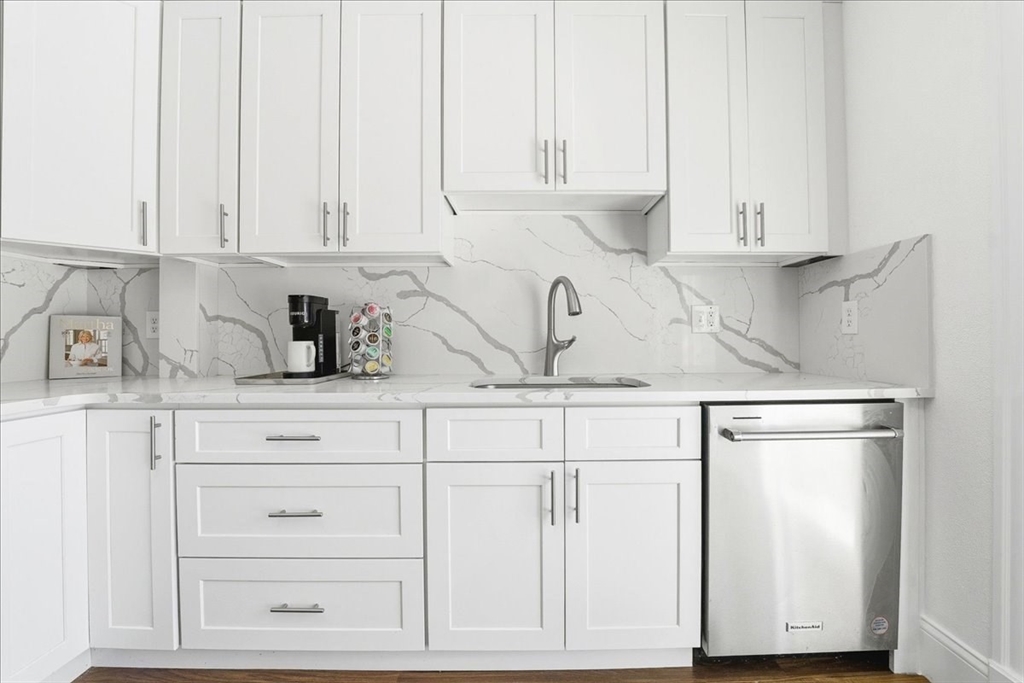 73 Hudson Street Milton, MA 02186 - Photo 7 of 42 a kitchen with granite countertop white cabinets and a sink