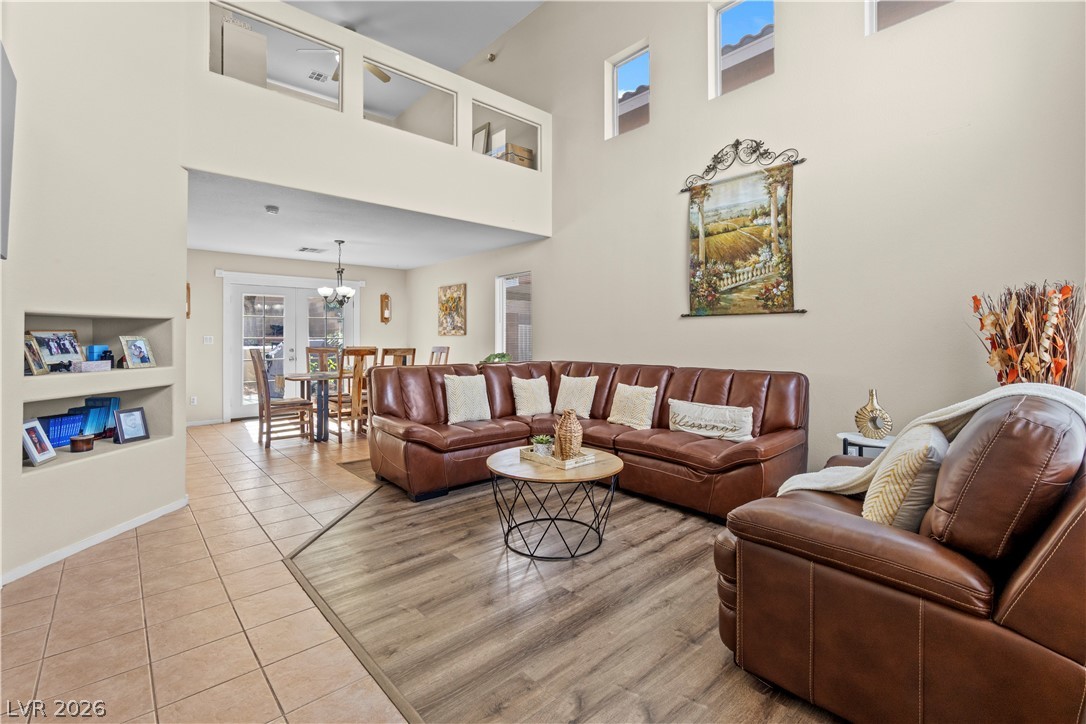 1419 Red Sunset Avenue Henderson, NV 89074 - Photo 6 of 35 Living area featuring light tile patterned floors, a high ceiling, built in features, and suspended lighting