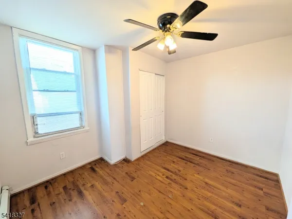 an empty room with a window and a fan