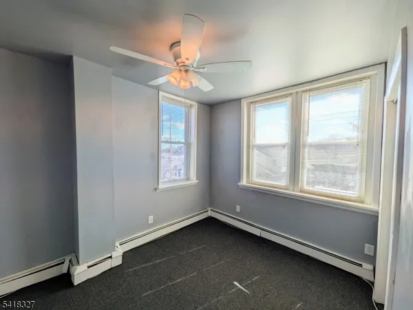 an empty room with a window and a fan