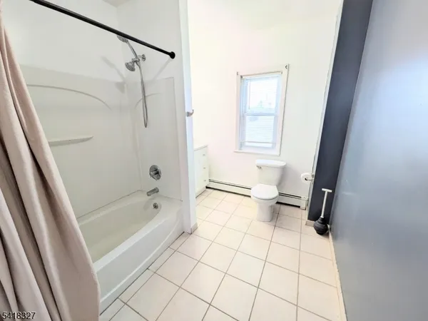 a bathroom with a shower a toilet a sink and a mirror
