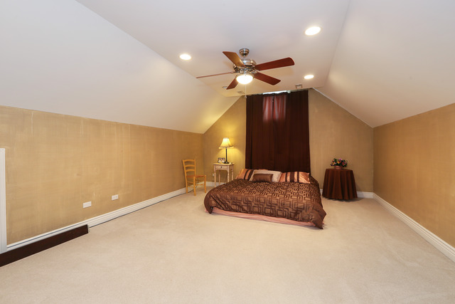 248 Highland Road Willowbrook, IL 60527 - Photo 16 of 25 a bedroom with a large bed and a chandelier