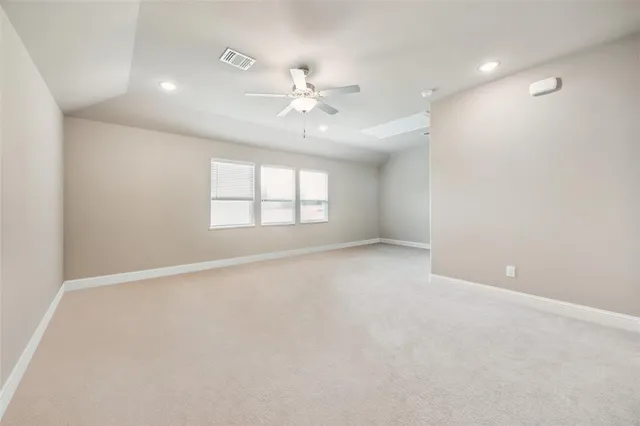 an empty room with windows and ceiling fan