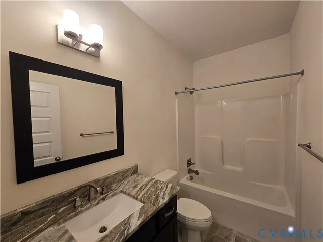 a bathroom with a sink vanity mirror and toilet