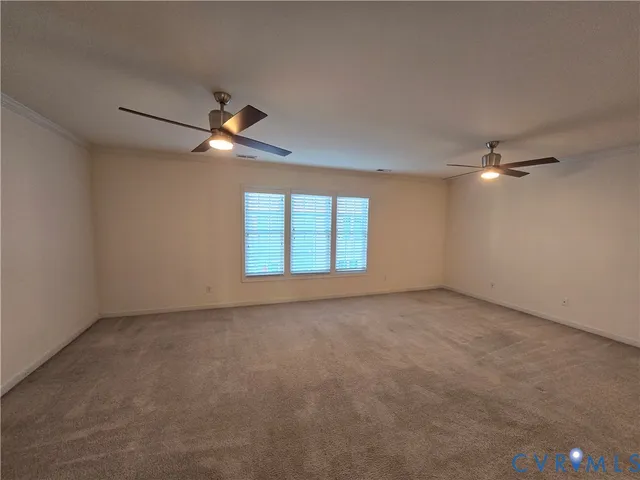en empty room with windows and ceiling fan