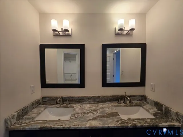 a bathroom with double vanity sinks and a mirror