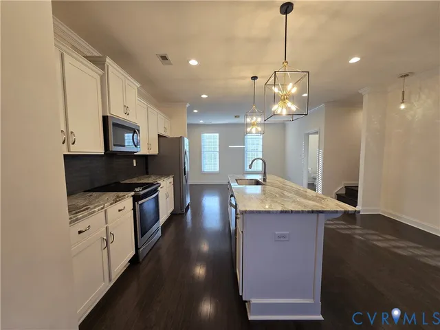 a kitchen with kitchen island granite countertop a stove and a sink