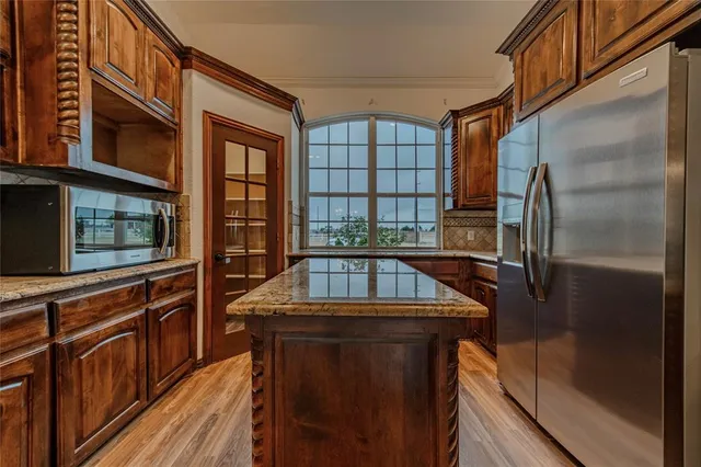 a view of entryway and kitchen with wooden floor