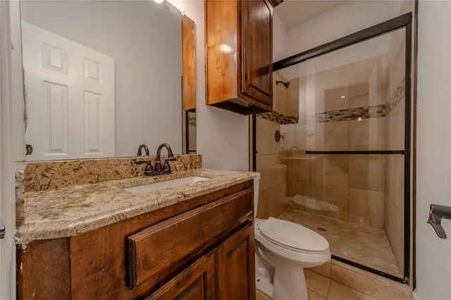 a bathroom with a granite countertop sink toilet and shower